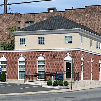 Brick orthodontic office building with cream-colored upper section and professional storefront entrance.