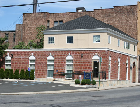 Brick orthodontics office building with white trim on corner street location
